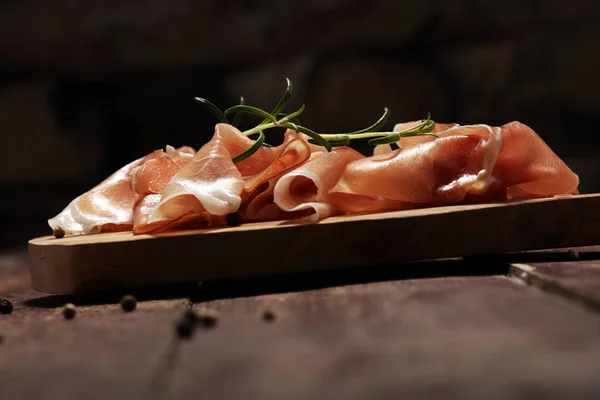 Crudo o marmellata di prosciutto italiano con rosmarino. Prosciutto crudo su ruggine — Foto Stock