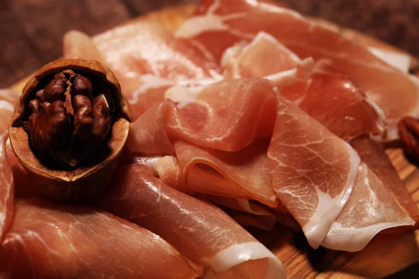 Italian prosciutto crudo or jamon with rosemary. Raw ham on rust — Stock Photo, Image