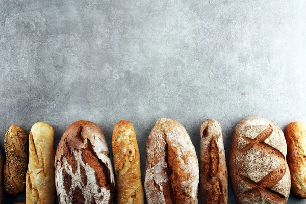 Assortiment van gebakken brood en broodjes op stenen tafel backgro — Stockfoto