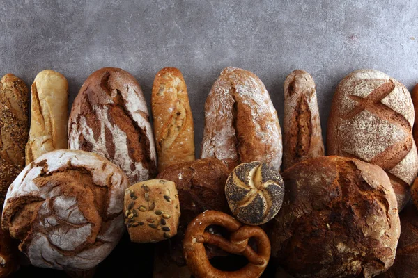 Assortiment van gebakken brood en broodjes op stenen tafel backgro — Stockfoto