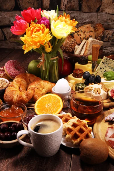Desayuno en la mesa con panecillos, croissants, café y huevos — Foto de Stock