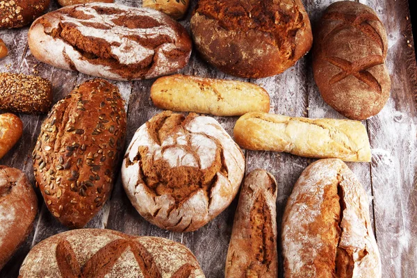 Verschiedene Arten von Brot und Brötchen an Bord von oben. ki — Stockfoto