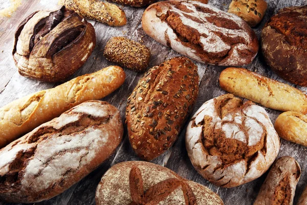 Různé druhy chleba a pečiva se valí na palubě shora. Ki — Stock fotografie