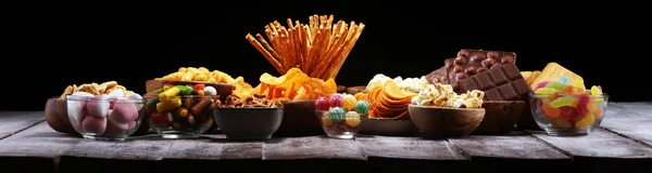 Salty snacks. Pretzels, chips, crackers in wooden bowls on table — Stock Photo, Image