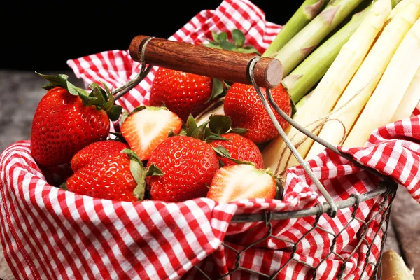 Espárragos blancos y verdes con fresas sobre madera — Foto de Stock