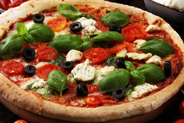 Pizza mit Tomaten, Mozzarella, schwarzen Oliven und Basilikum. — Stockfoto