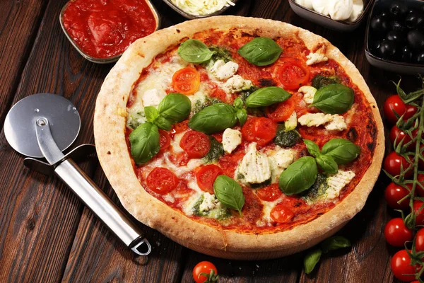 Pizza mit Tomaten, Mozzarella, schwarzen Oliven und Basilikum. — Stockfoto