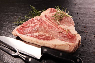 Taş kesme tahtası üzerinde ham T-bone biftek.