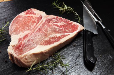 Taş kesme tahtası üzerinde ham T-bone biftek.