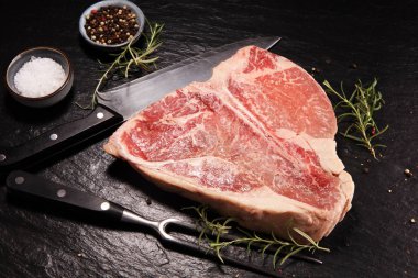 Taş kesme tahtası üzerinde ham T-bone biftek.