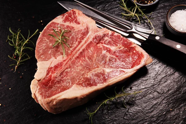 Taş kesme tahtası üzerinde ham T-bone biftek. — Stok fotoğraf