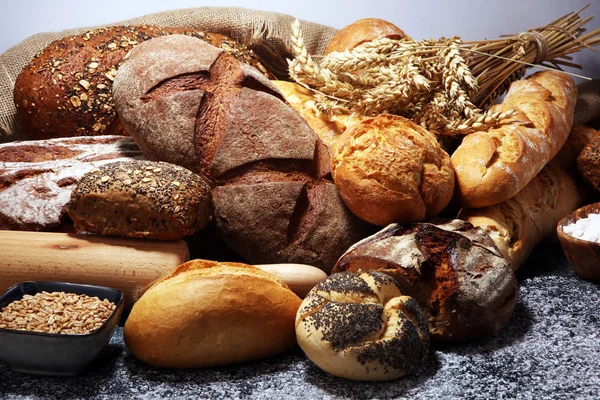 Асортимент запеченого хліба і хлібних рулетів на сільській сірій пекарні — стокове фото