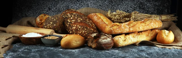 Surtido de panes horneados y panecillos en panadería rústica gris —  Fotos de Stock