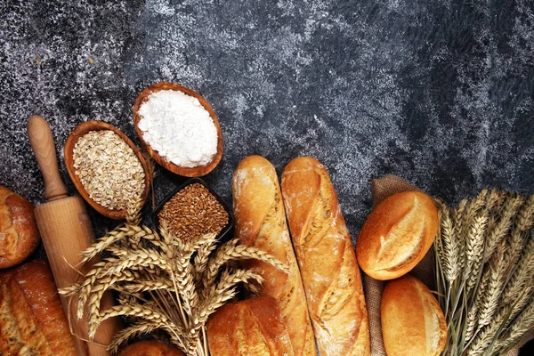 Asortyment wypieków chleba i bułek w rustykalnej, szarej piekarni — Zdjęcie stockowe