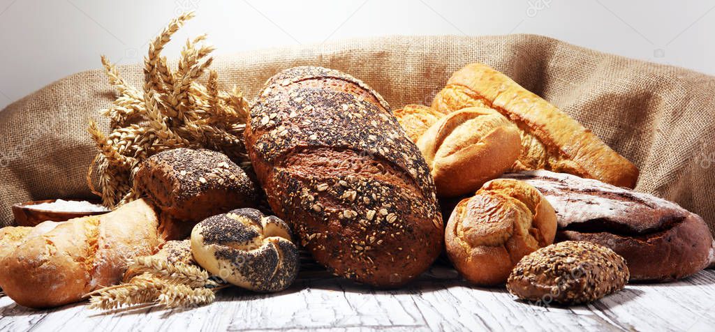 Assortment of baked bread and bread rolls on rustic white bakery