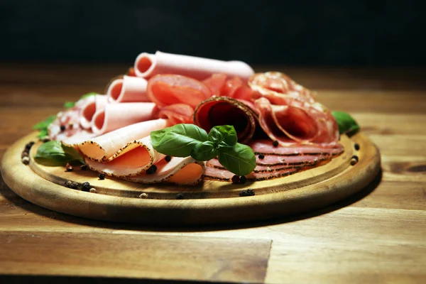 Food tray with delicious salami, pieces of sliced ham, sausages, — Stock Photo, Image