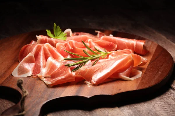 Włoskiego prosciutto crudo lub jamon z rozmarynem. Surowa szynka na drewno — Zdjęcie stockowe