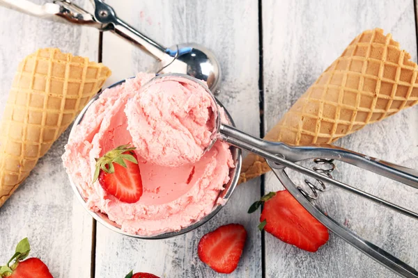 Strawberry ice cream scoop on a rustic white background with fre