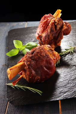 Taş tabakta baharat ve bitkilerle tütsülenmiş jambon..