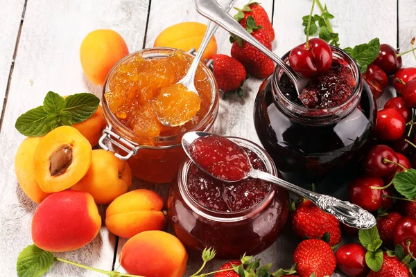 Assortment of jams, seasonal berries, apricot, mint and fruits. — Stock Photo, Image