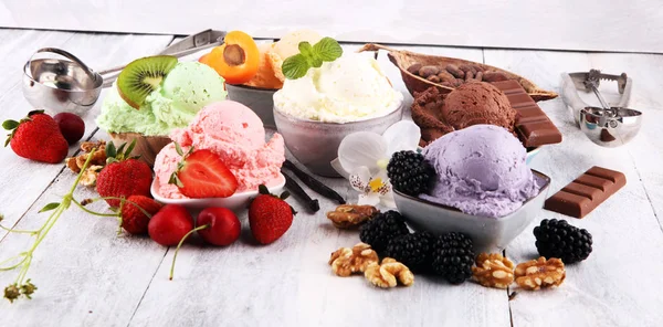 Cucharadas de helado de diferentes colores y sabores con bayas , —  Fotos de Stock