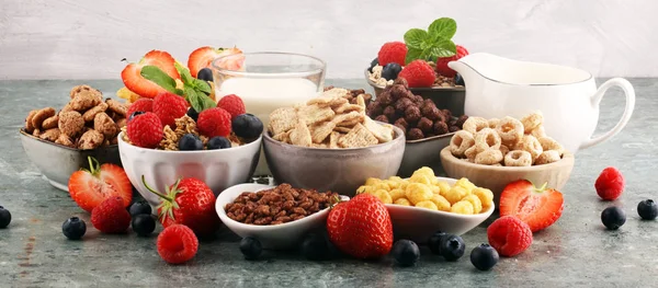 Cereales. Tazones de diversos cereales, bayas y leche para el desayuno —  Fotos de Stock