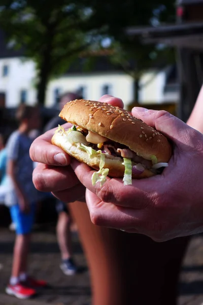 Organic Burger on street food festival in hand. Pulled pork or b