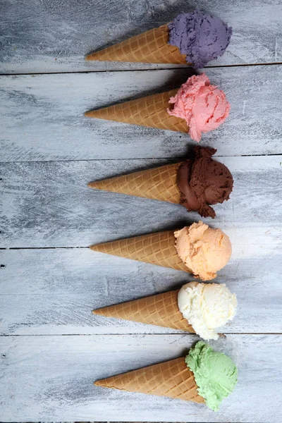 Palline di gelato di diversi colori e sapori con frutti di bosco , — Foto Stock