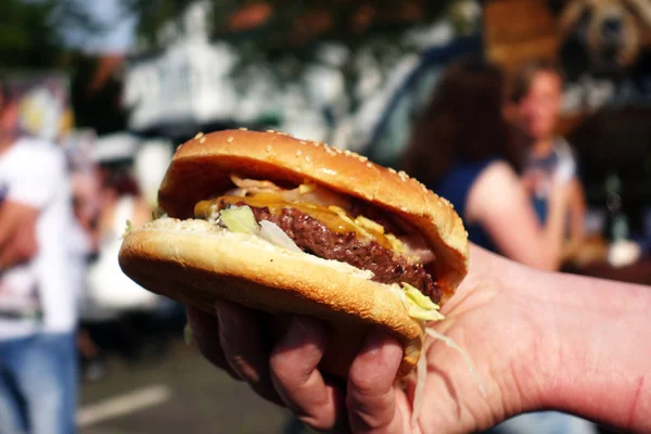 Organic Burger on street food festival in hand. Pulled pork or b