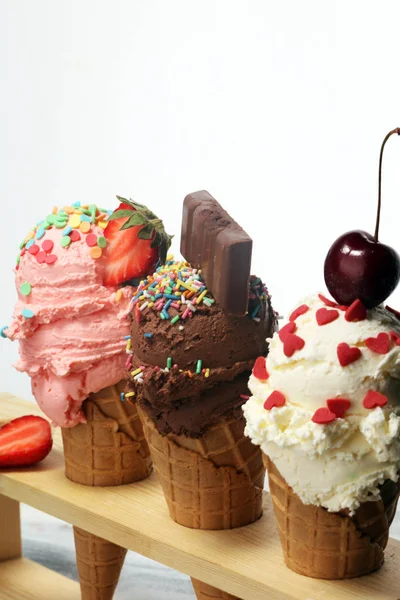 Cucharadas de helado de diferentes colores y sabores con bayas , —  Fotos de Stock