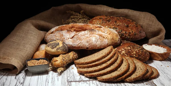 Ποικιλία από ψημένο ψωμί και ψωμάκια σε ρουστίκ λευκό φούρνο — Φωτογραφία Αρχείου