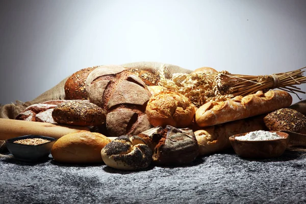 Assortiment van gebakken brood en broodjes op rustieke grijze bakkerij — Stockfoto