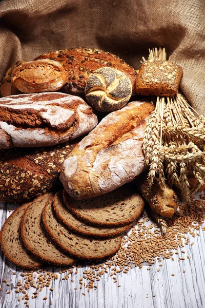 Assortiment van gebakken brood en broodjes op rustieke witte bakkerij — Stockfoto