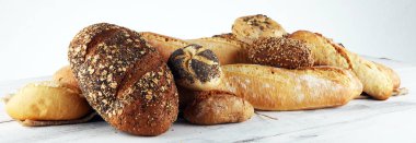 Beyaz masa backgro üzerinde pişmiş ekmek ve ekmek rulo çeşitleri