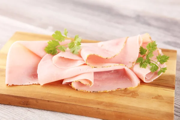 Sliced ham with parsley on table. Fresh prosciutto. Pork ham sli