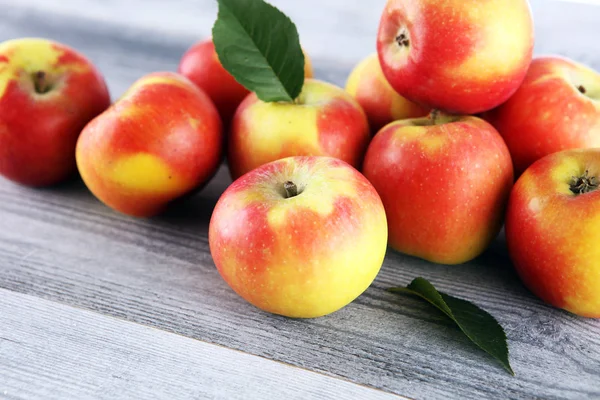 Pommes rouges mûres avec des feuilles sur fond en bois — Photo