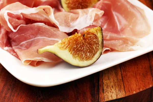 Italian prosciutto crudo or jamon with sliced figs Raw ham. — Stock Photo, Image