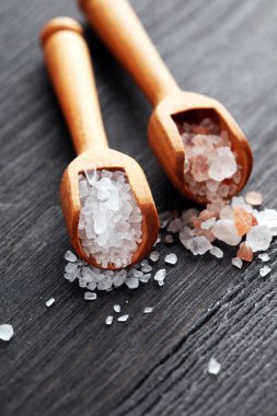Kaşıkta deniz tuzu ve himalaya. Koyu backgr üzerinde tuz kristalleri