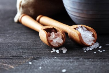 Kaşıkta deniz tuzu ve himalaya. Koyu backgr üzerinde tuz kristalleri