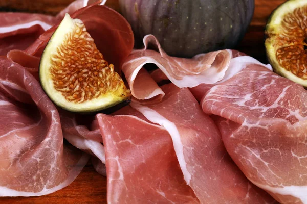 Italienska prosciutto Crudo eller Jamon med skivade fikon rå skinka. — Stockfoto