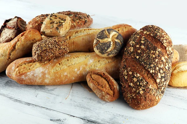 Assortiment gebakken brood en broodjes op witte tafel blauw — Stockfoto