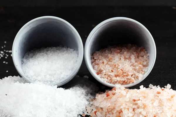 Garam laut dan himalayan dalam mangkuk. Kristal garam pada backgro gelap — Stok Foto