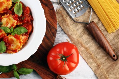 Mantı domates soslu parmesan peyniri ve bas ile süslenmiş