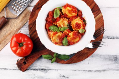 Mantı domates soslu parmesan peyniri ve bas ile süslenmiş