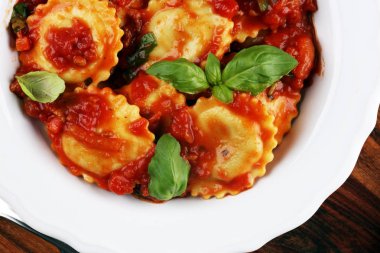 Mantı domates soslu parmesan peyniri ve bas ile süslenmiş