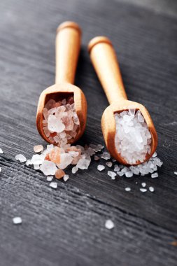 Kaşıkta deniz tuzu ve himalaya. Koyu backgr üzerinde tuz kristalleri