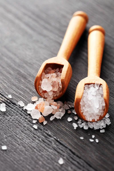 Kaşıkta deniz tuzu ve himalaya. Koyu backgr üzerinde tuz kristalleri