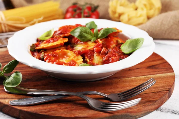 Mantı domates soslu parmesan peyniri ve bas ile süslenmiş