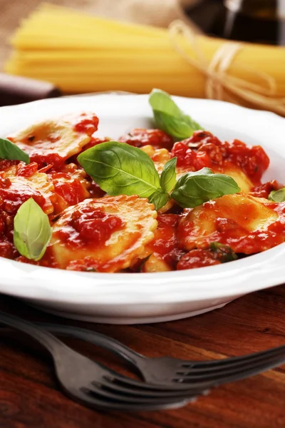 Mantı domates soslu parmesan peyniri ve bas ile süslenmiş