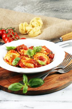 Mantı domates soslu parmesan peyniri ve bas ile süslenmiş